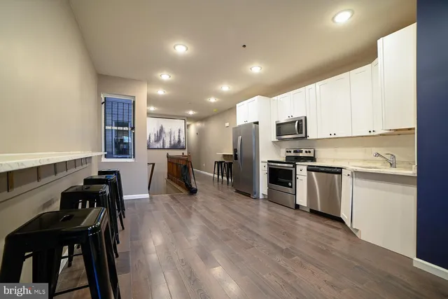a kitchen with white cabinets and stainless steel appliances
