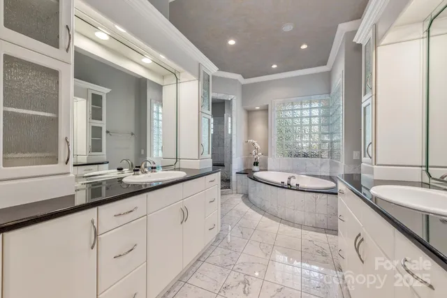 a large bathroom with a granite countertop tub sink and mirror