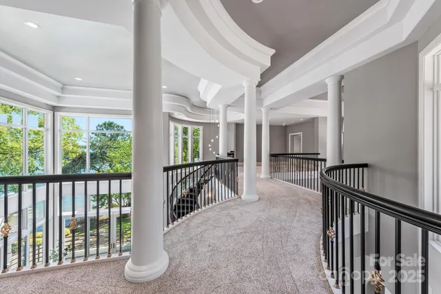 a view of a hallway with wooden floor and windows
