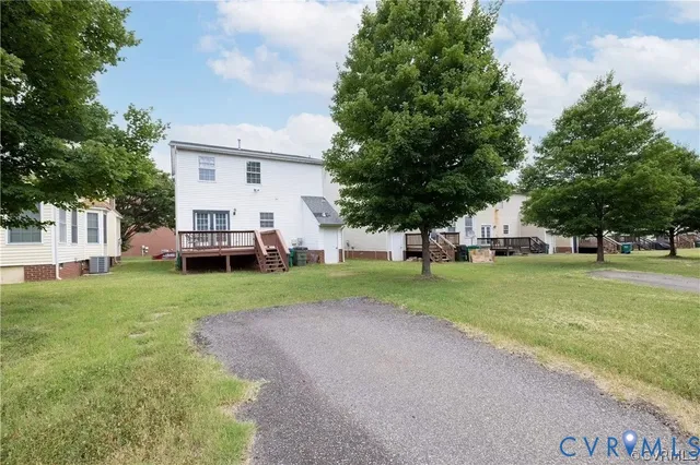 a view of a house with backyard and trees