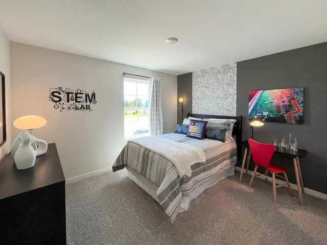 a spacious bedroom with a bed and dresser