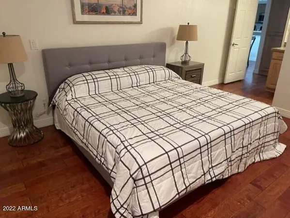 a bedroom with bed and wooden floor