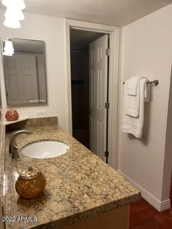 a bathroom with a granite countertop sink and a mirror