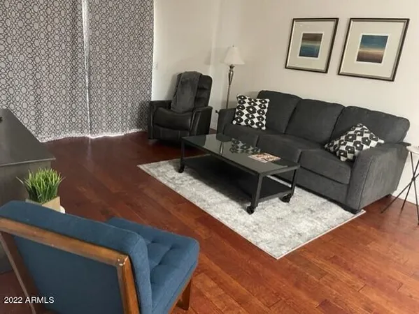 a living room with furniture and wooden floor