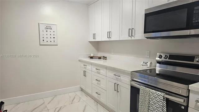 a kitchen with stainless steel appliances white cabinets and a stove top oven