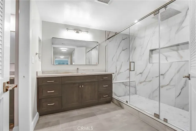 a bathroom with a double vanity sink mirror and shower