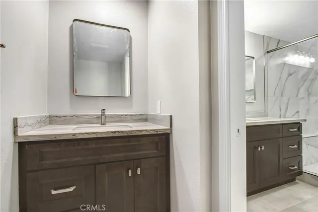 a bathroom with a granite countertop sink and a mirror