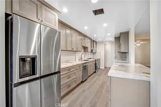 a kitchen with stainless steel appliances a refrigerator sink and cabinets