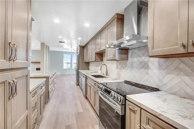 a kitchen with stainless steel appliances granite countertop a sink a stove and a refrigerator