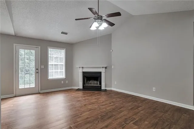 a view of an empty room with a window and fireplace