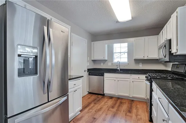 a kitchen with stainless steel appliances granite countertop a refrigerator stove and sink