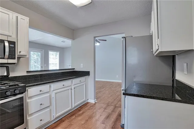 a kitchen with granite countertop a sink and a stove top oven