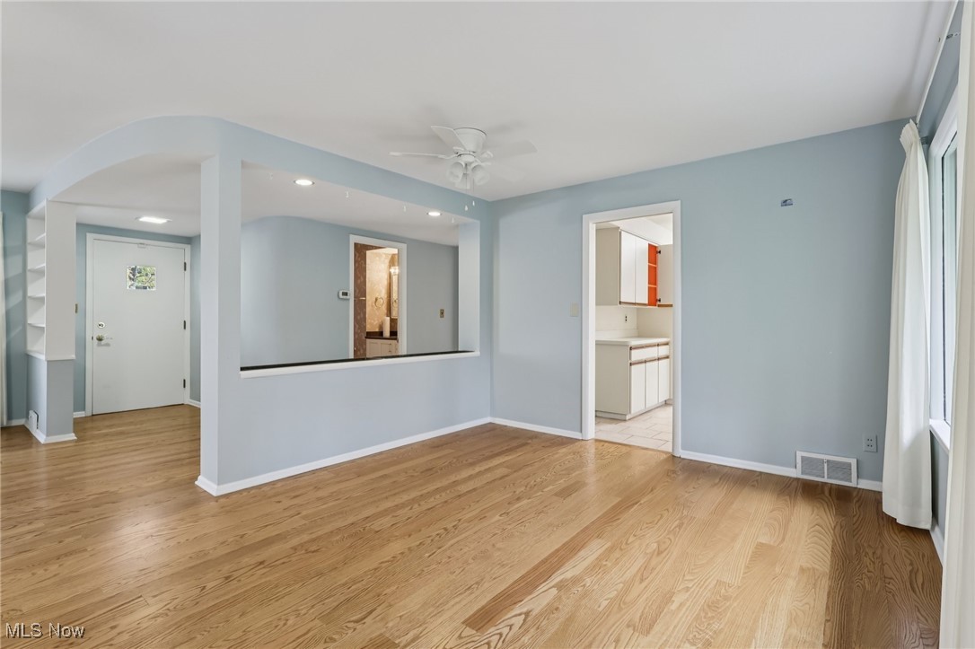 33300 South Woodland Road Cleveland, OH 44124 - Photo 10 of 50 Unfurnished living room with a ceiling fan, light wood-style floors, recessed lighting, and arched walkways