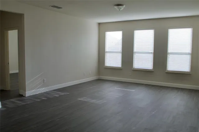 an empty room with wooden floor and a window