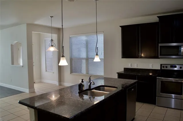 a kitchen with granite countertop stove top oven and cabinets