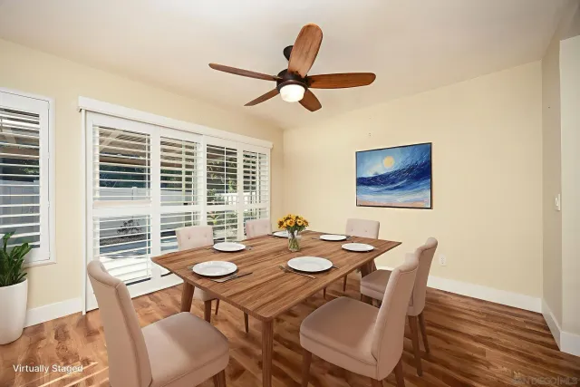 a dining room with furniture a window and a ceiling fan