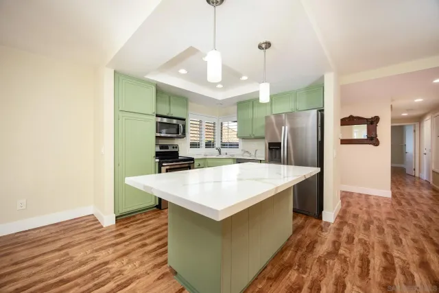 a kitchen with stainless steel appliances kitchen island a refrigerator and a sink