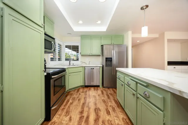 a kitchen with a sink a counter top space stainless steel appliances and cabinets