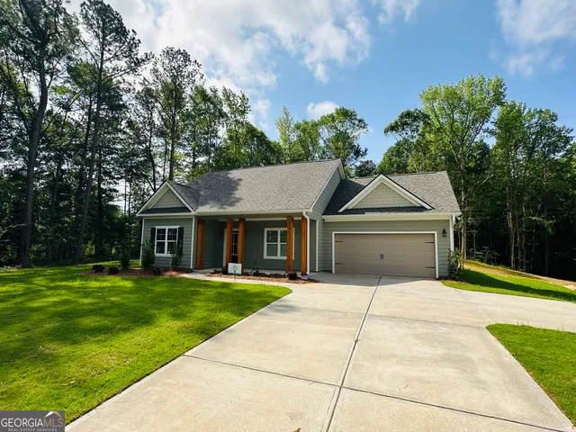 a front view of a house with a yard and trees