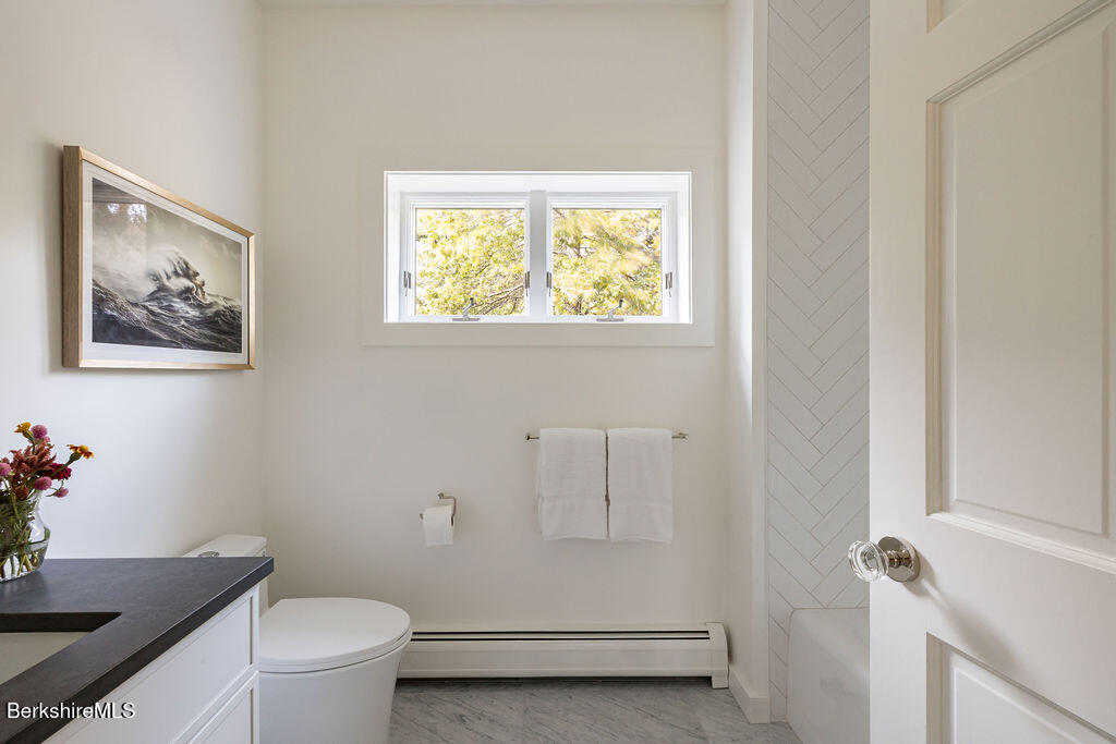 302 A Egremont Plain Road Egremont, MA 01230 - Photo 39 of 66 a bathroom with a granite countertop toilet a sink and a window