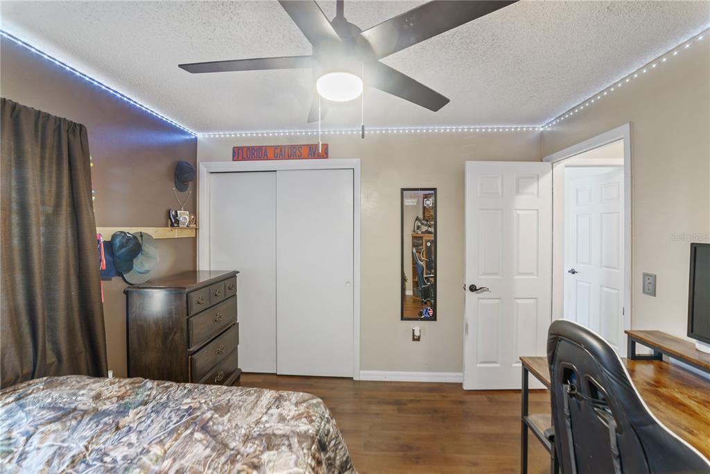 8715 Huntsman Lane Port Richey, FL 34668 - Photo 34 of 54 a bedroom with a bed and wooden floor