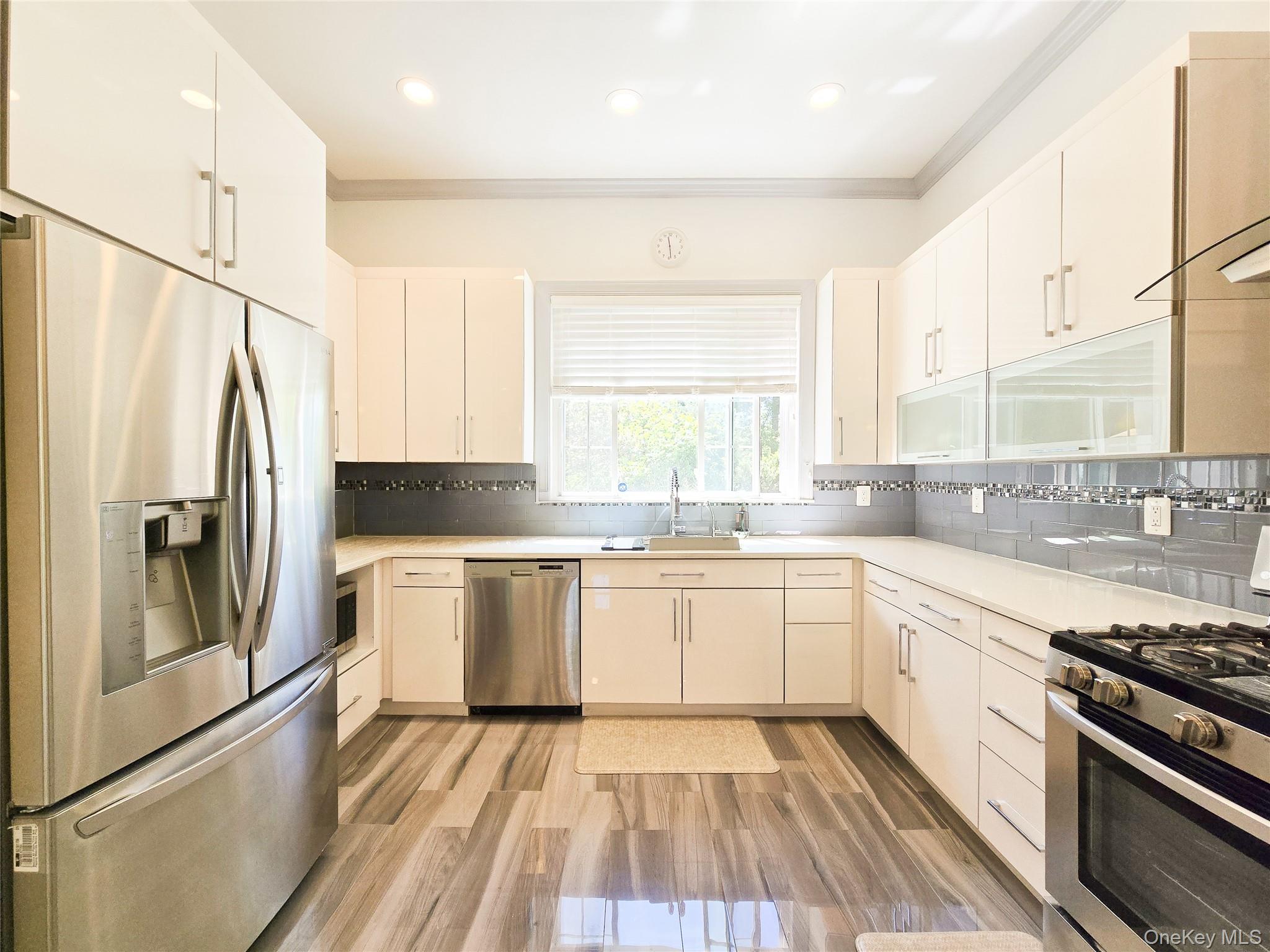 249 Cold Spring Road Syosset, NY 11791 - Photo 10 of 28 a kitchen with stainless steel appliances granite countertop a stove a sink and a refrigerator