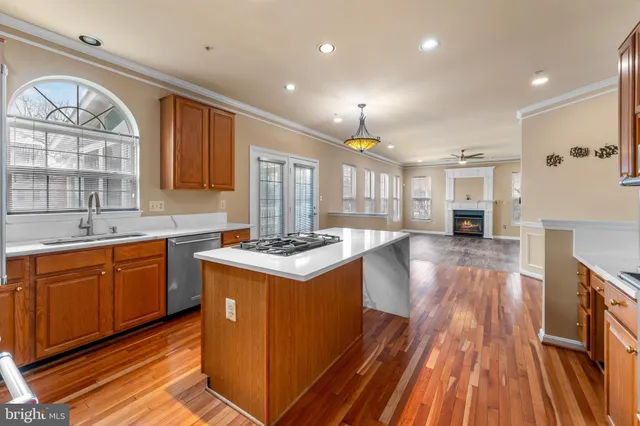 a kitchen with wooden floors and a view of living room