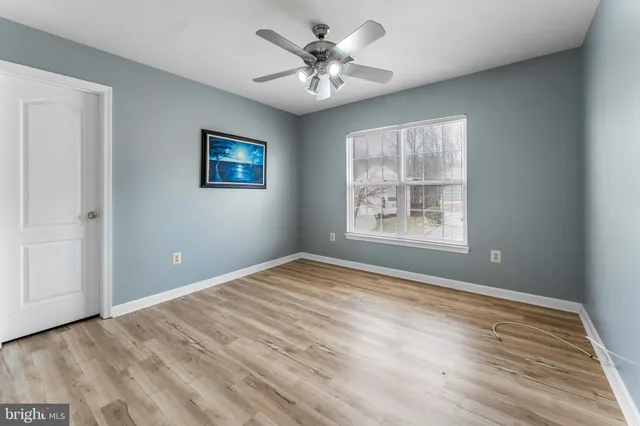 a view of a livingroom with wooden floor and a kitchen space