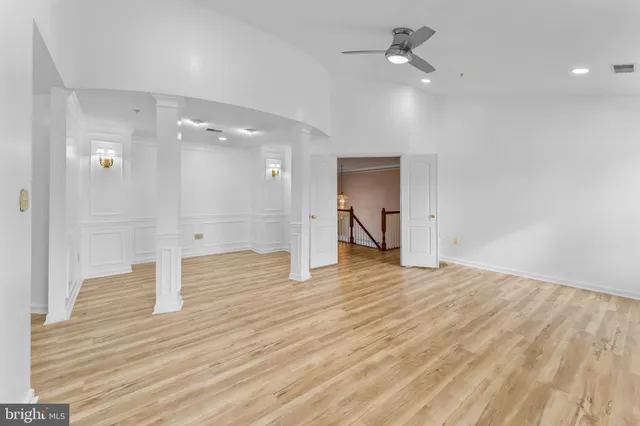 a view of a bedroom with wooden floor and a ceiling fan