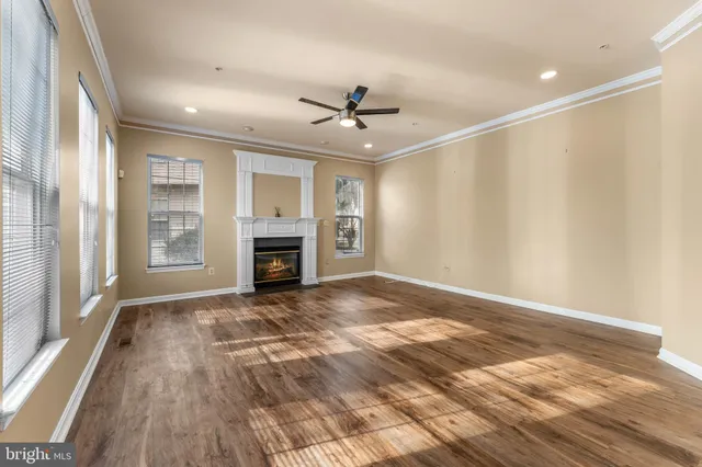 wooden floor in an empty room with a chandelier fan