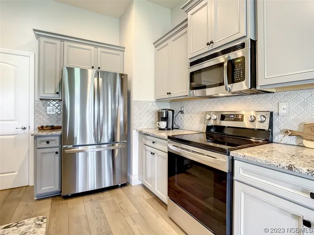 a kitchen with stainless steel appliances granite countertop a refrigerator microwave and stove top oven