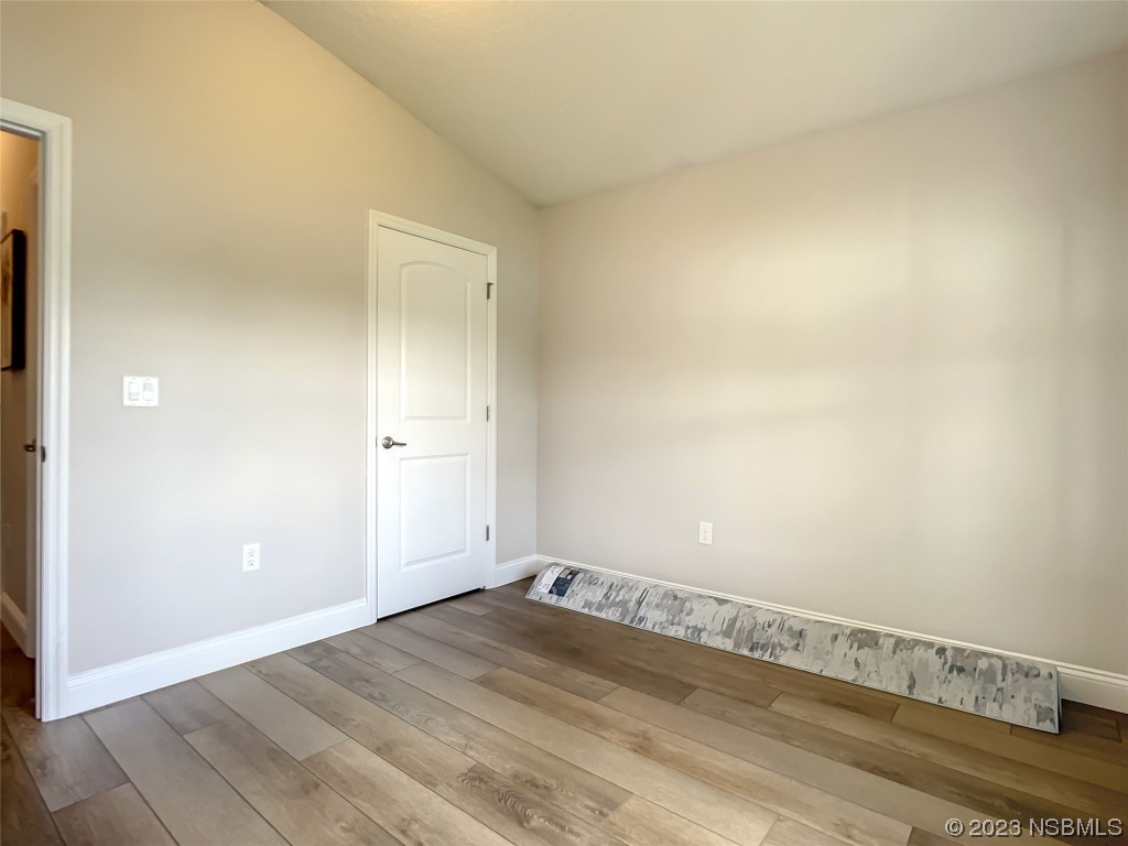 512 Coral Trace Boulevard Edgewater, FL 32132 - Photo 15 of 45 an empty room with wooden floor and windows