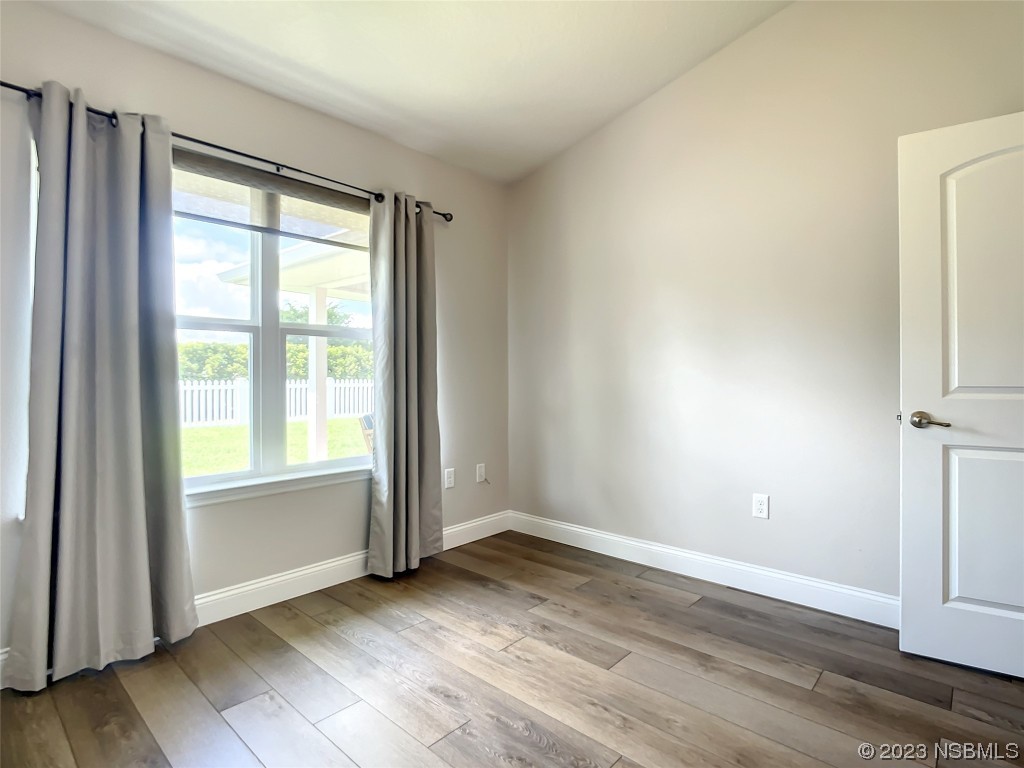 512 Coral Trace Boulevard Edgewater, FL 32132 - Photo 16 of 45 an empty room with wooden floor and windows