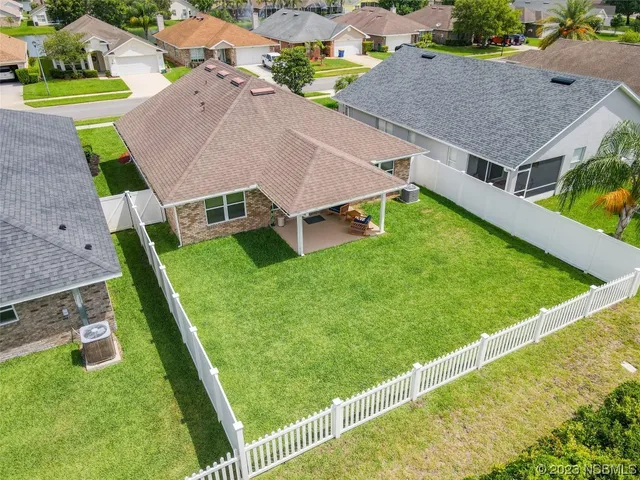 an aerial view of residential houses with outdoor space and trees