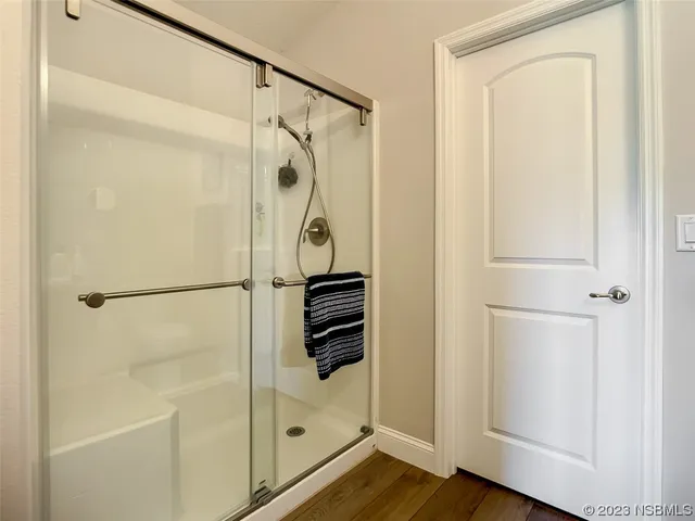 a bathroom with a shower and a glass door