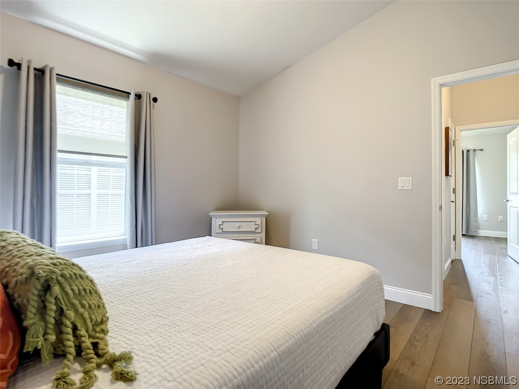 512 Coral Trace Boulevard Edgewater, FL 32132 - Photo 24 of 45 a bedroom with a bed and wooden floor