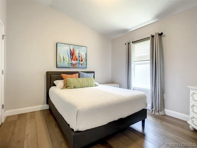 a bedroom with a bed and wooden floor