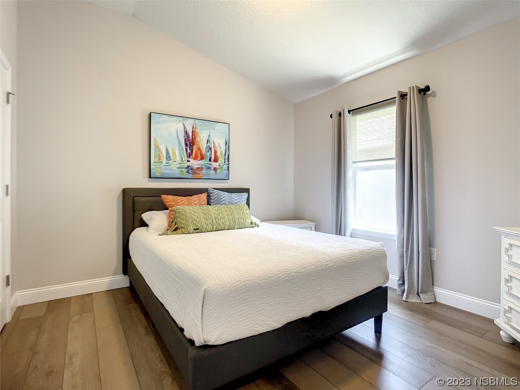 512 Coral Trace Boulevard Edgewater, FL 32132 - Photo 25 of 45 a bedroom with a bed and wooden floor