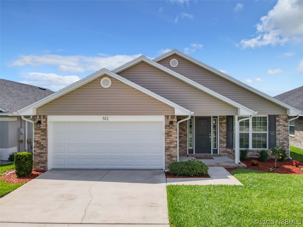 512 Coral Trace Boulevard Edgewater, FL 32132 - Photo 3 of 45 a front view of a house with a yard and garage