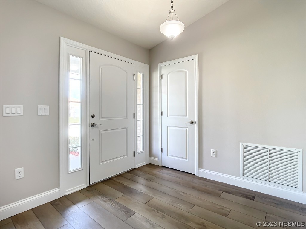 512 Coral Trace Boulevard Edgewater, FL 32132 - Photo 4 of 45 an empty room with wooden floor and windows