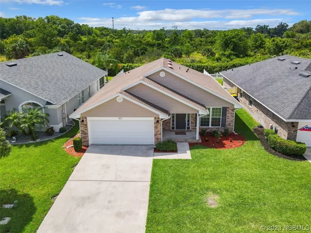 an aerial view of a house with table and chairs
