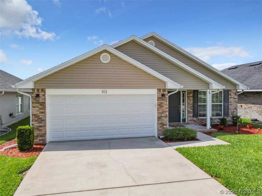 512 Coral Trace Boulevard Edgewater, FL 32132 - Photo 45 of 45 a front view of a house with a yard and garage