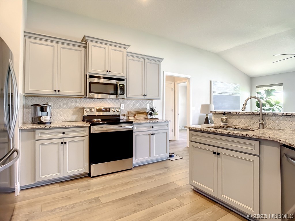 512 Coral Trace Boulevard Edgewater, FL 32132 - Photo 7 of 45 a kitchen with granite countertop white cabinets and appliances
