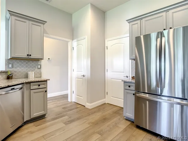 a kitchen with stainless steel appliances a refrigerator and wooden cabinets