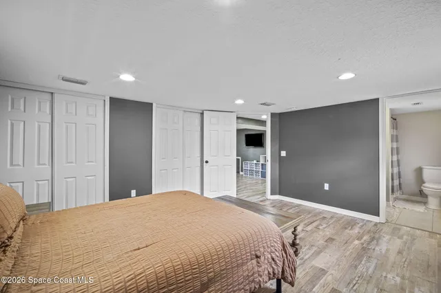 a bedroom with a large bed and a bathroom