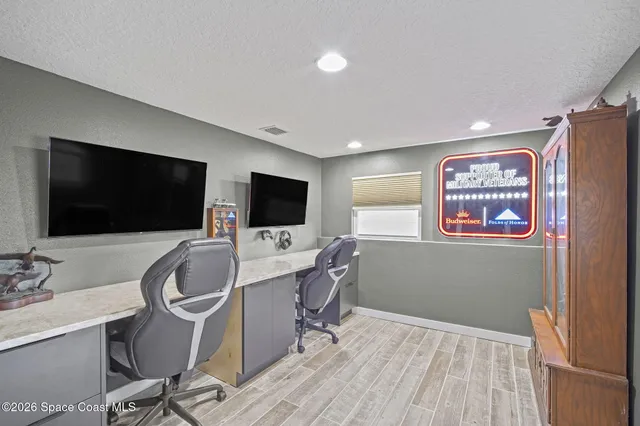 a view of a workspace with furniture and a flat screen tv