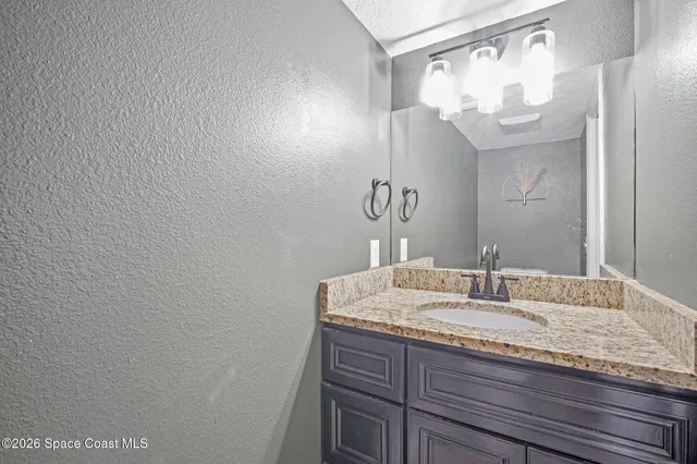 a bathroom with a granite countertop sink and a mirror
