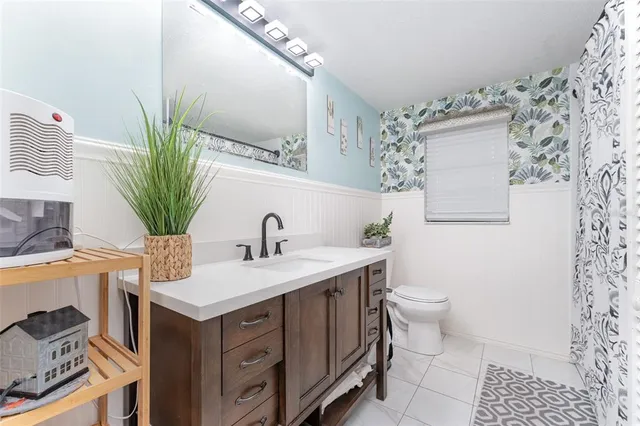a bathroom with a granite countertop sink a toilet and mirror
