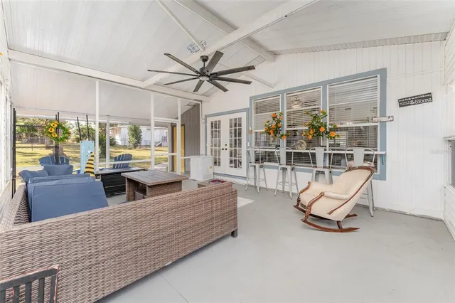 a living room with furniture gym equipment and large windows