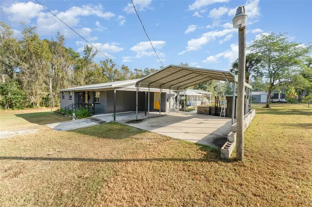 a view of a house with backyard and tree